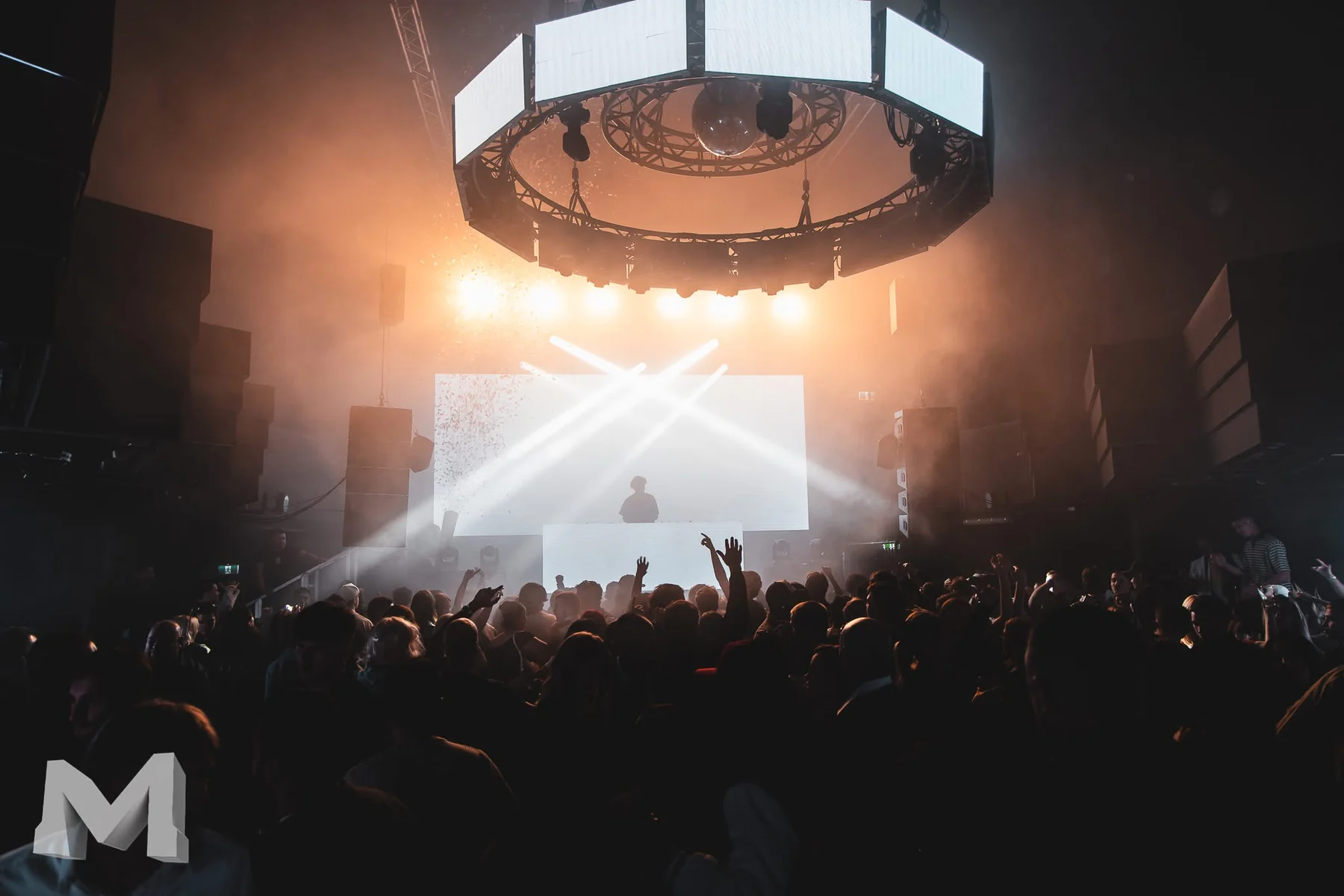 HASLOOM performing in front of a bright stage